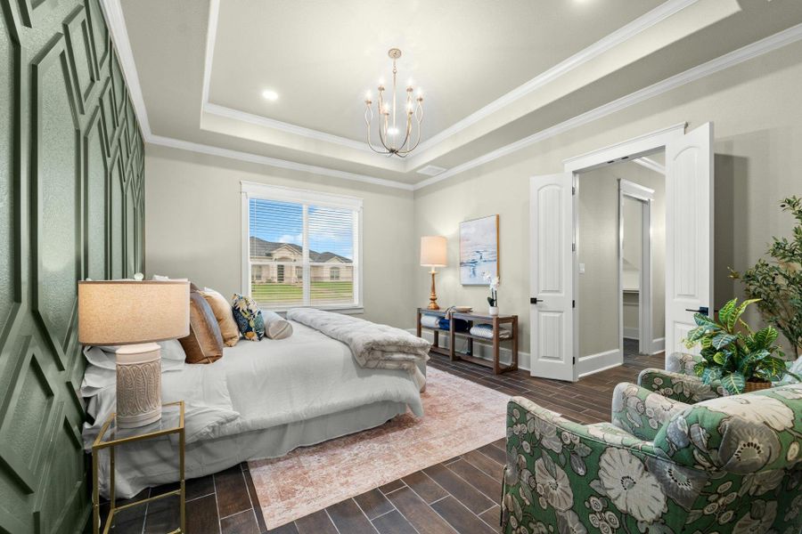Bedroom featuring a tray ceiling with recessed lighting and a chandelier