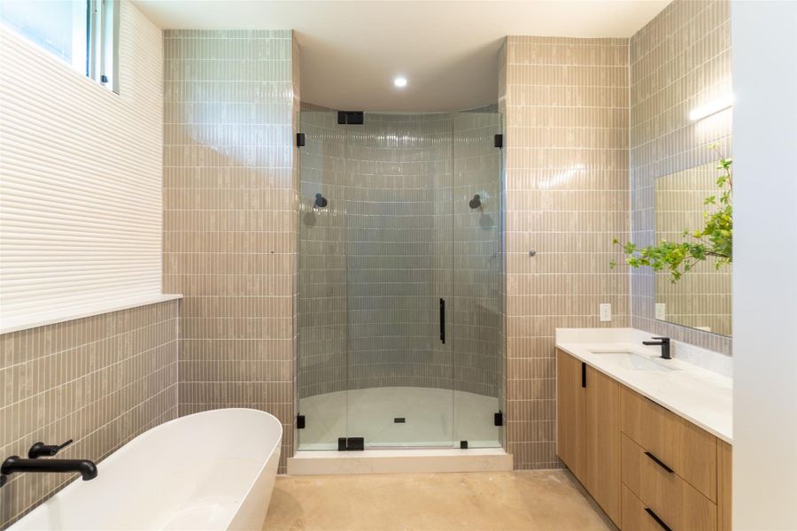 Full bath with tile walls, a soaking tub, vanity, and a shower stall Full bath with tile walls, a soaking tub, vanity, and a shower stall