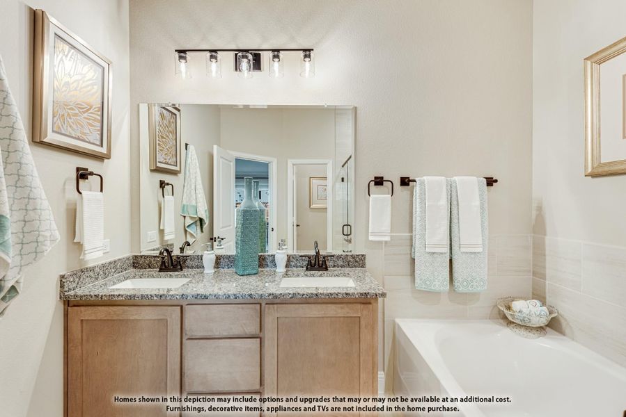 Bathroom with double sink vanity, granite countertops, large mirror, and soaking tub Bathroom with double sink vanity, granite countertops, large mirror, and soaking tub