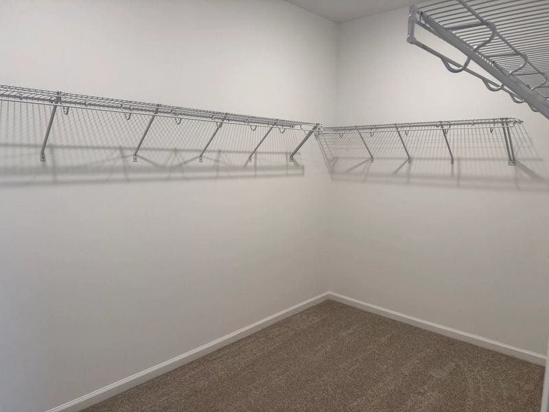 Primary Walk-In featuring the AW Collection® Serene - Open storage with understated design.