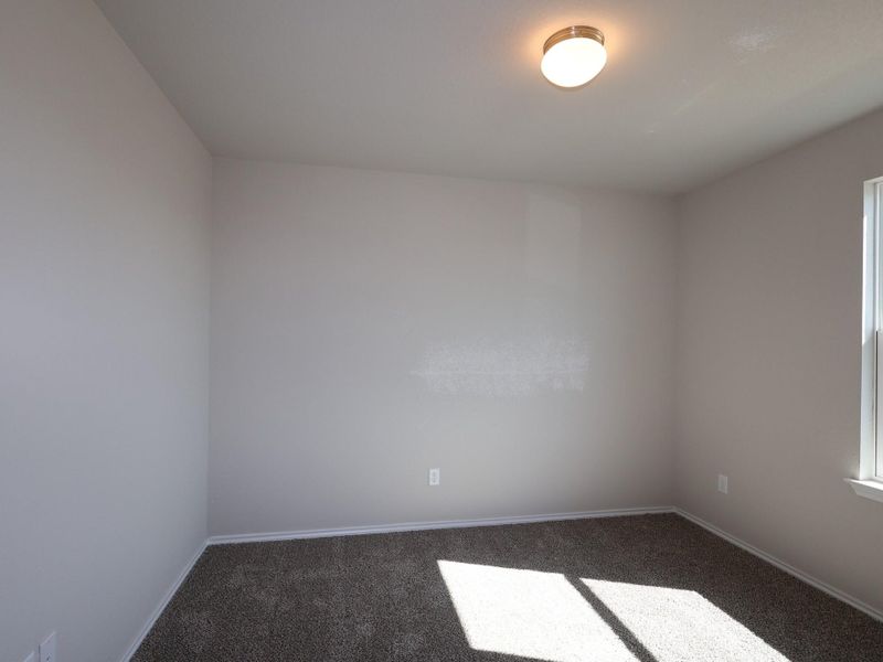 Unfurnished room with baseboards and dark colored carpet