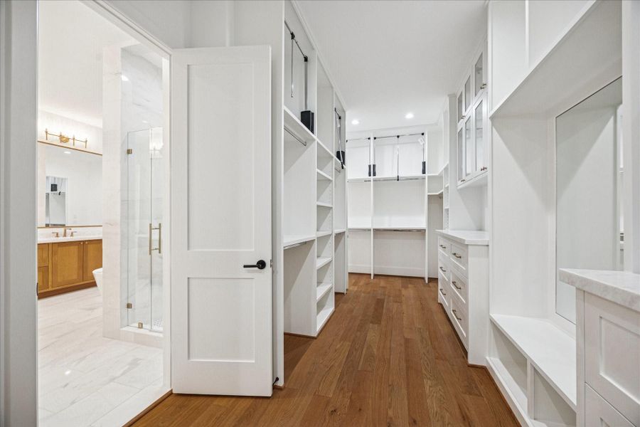 Expansive walk in wardrobe designed for true organization, offering custom cabinetry, abundant shelving, built in drawer stacks, and double hanging systems with pull downs for easy access. A marble topped dressing station and integrated mirror create a boutique inspired dressing experience, while the thoughtful layout maximizes usable space and storage efficiency. Expansive walk in wardrobe designed for true organization, offering custom cabinetry, abundant shelving, built in drawer stacks, and double hanging systems with pull downs for easy access. A marble topped dressing station and integrated mirror create a boutique inspired dressing experience, while the thoughtful layout maximizes usable space and storage efficiency.