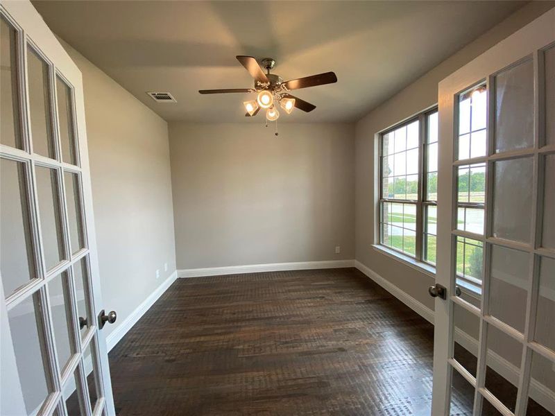 Elegant office with French doors, rich hardwood floors, and ceiling fan