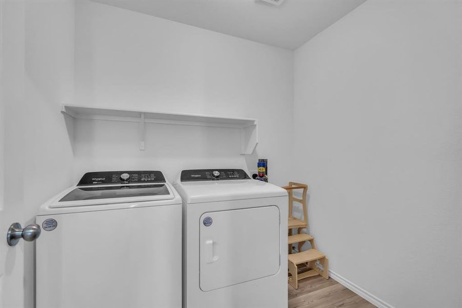 Washroom featuring light wood-style floors and washing machine and dryer