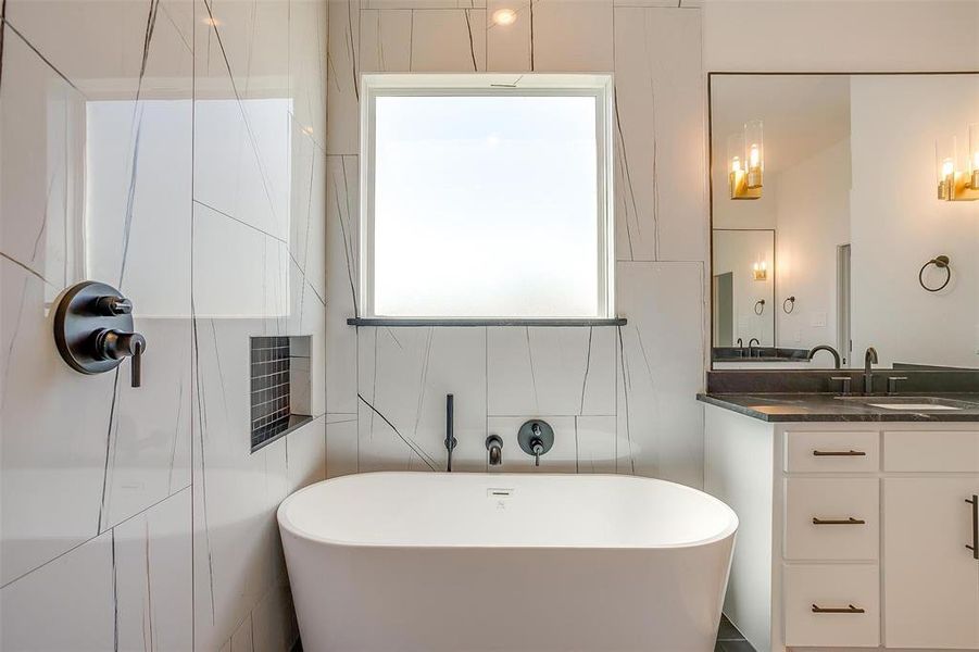 Bathroom with a washtub, oversized vanity, and tile walls