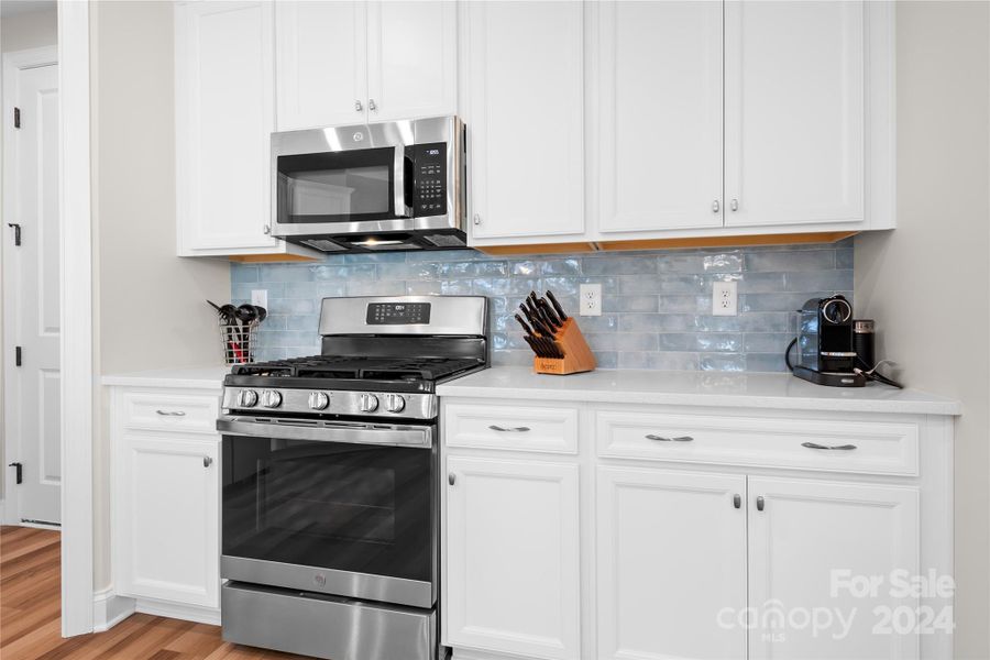 Beautiful tile backsplash is the perfect compliment to this light and bright Kitchen which also features a natural GAS range.