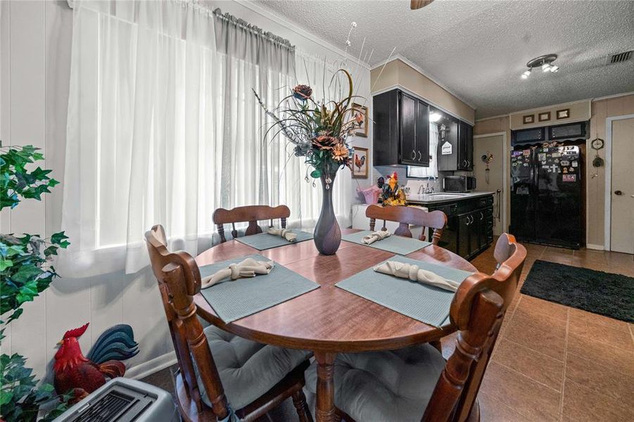 Dining room with crown molding and a textured ceiling