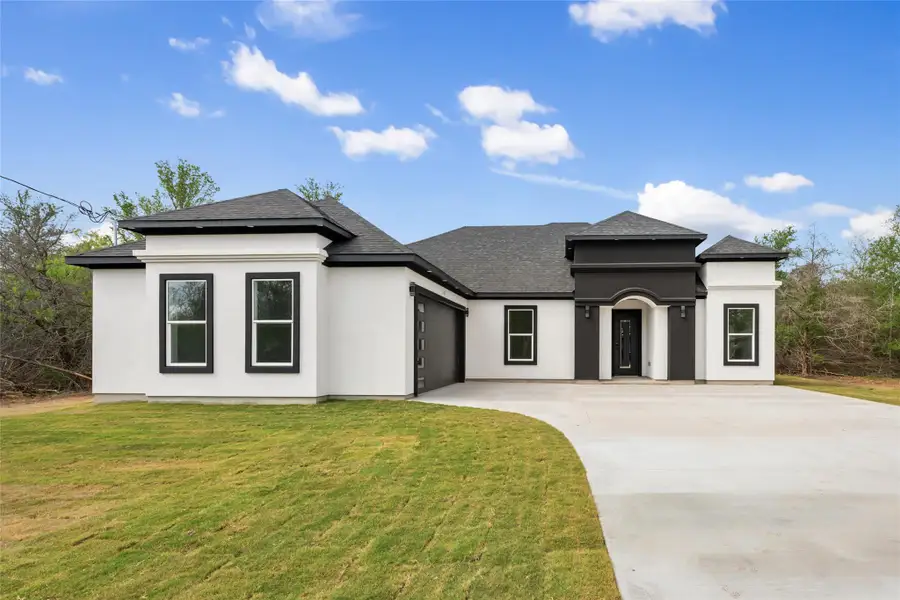 Prairie-style home with an attached garage, driveway, a front lawn, and stucco siding Prairie-style home with an attached garage, driveway, a front lawn, and stucco siding