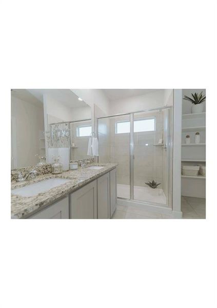 Bathroom featuring walk in shower, tile patterned floors, and vanity