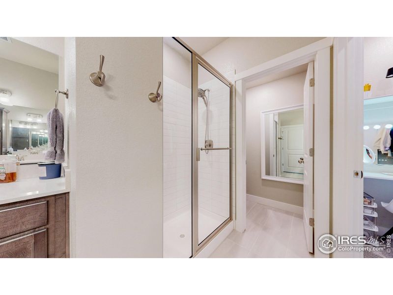 Primary suite shower and walk-in closet to the right