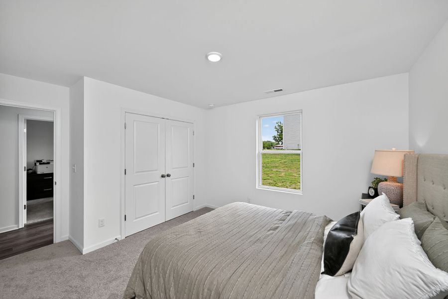 A bedroom with a bed and a couch.