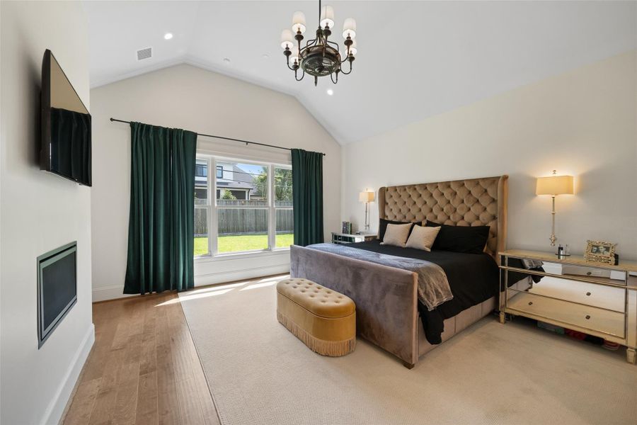 The large primary bedroom, located on the first floor, boasts soaring ceilings and generous windows that overlook the backyard. It also offers direct access to the backyard.