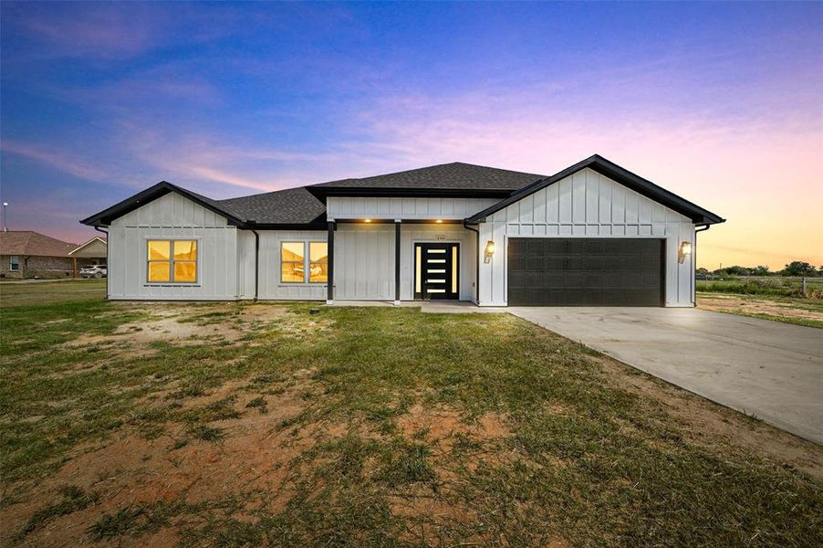 Modern farmhouse style home with a yard and a garage