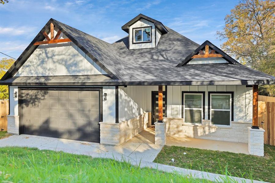 View of front of home with a garage and covered porch