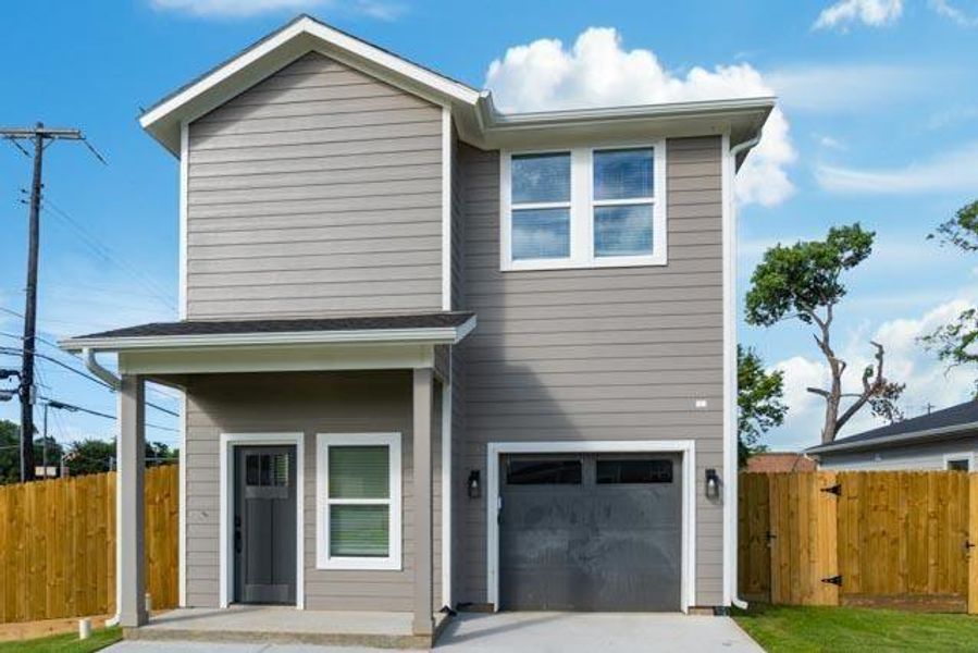 View of front facade featuring a garage and concrete driveway