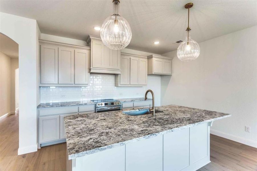 Kitchen featuring a sink, stainless steel electric range, baseboards, light wood-style floors, and recessed lighting