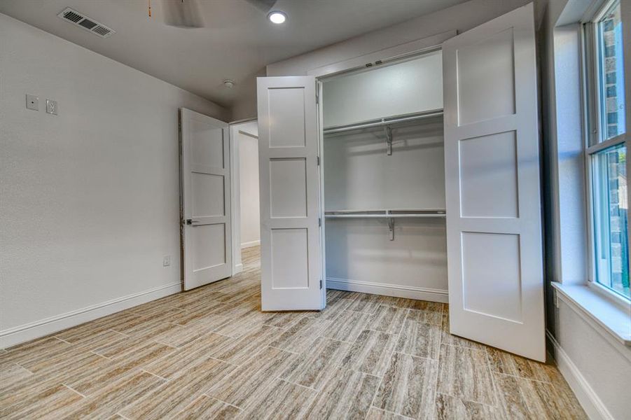 Unfurnished bedroom featuring a closet, light hardwood / wood-style flooring, and multiple windows