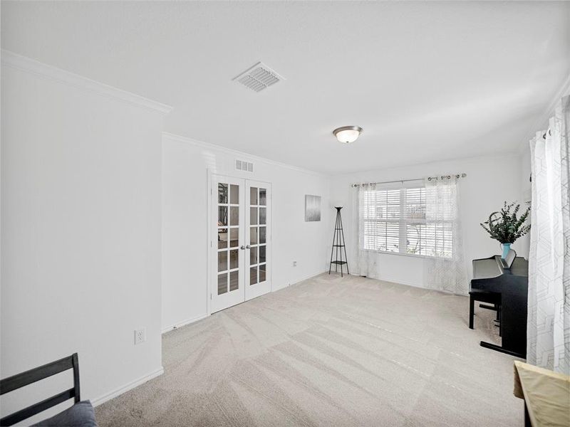 Unfurnished room with french doors, visible vents, and crown molding