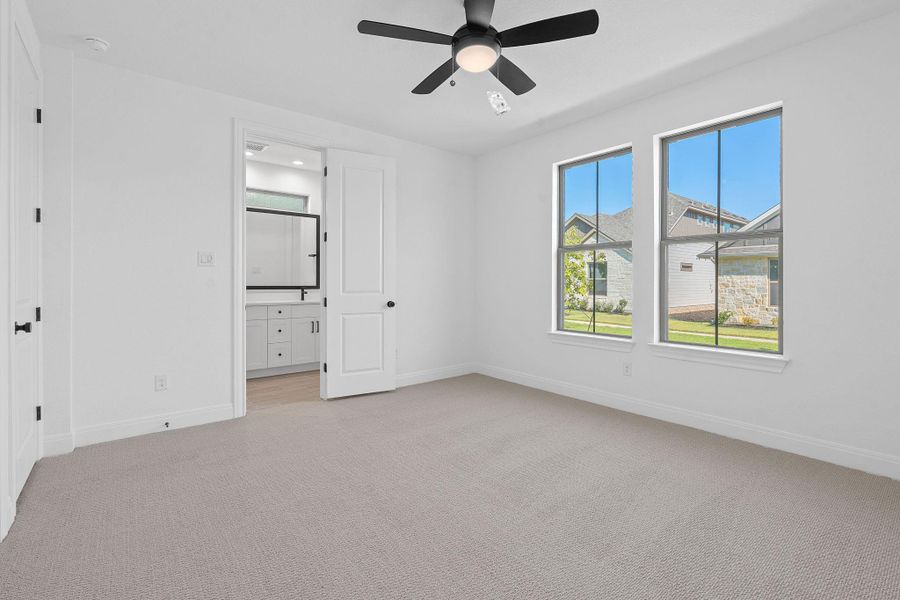 Unfurnished bedroom featuring light carpet, a ceiling fan, and ensuite bath Unfurnished bedroom featuring light carpet, a ceiling fan, and ensuite bath