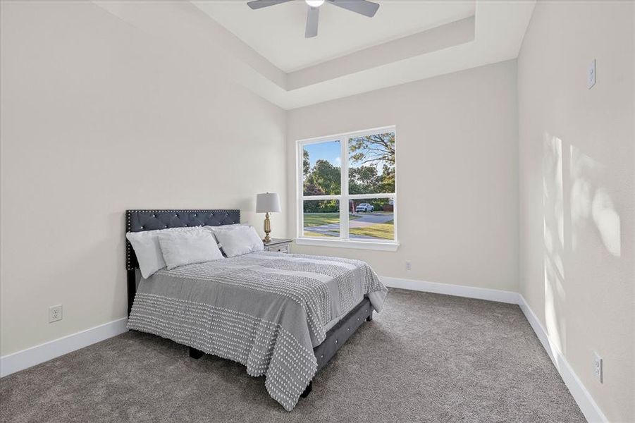 Spacious room with a tray ceiling, recessed lighting, and a ceiling fan Spacious room with a tray ceiling, recessed lighting, and a ceiling fan