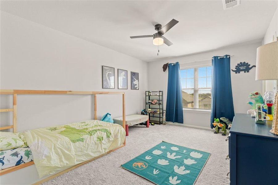 Upstairs bedroom with carpet, ceiling fan, and spacious walk-in closet