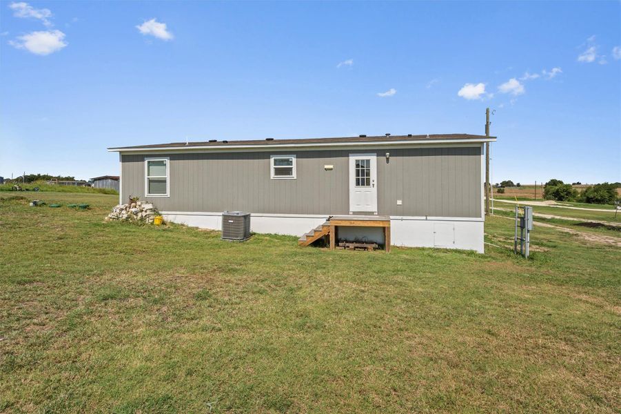 Back of property featuring a lawn