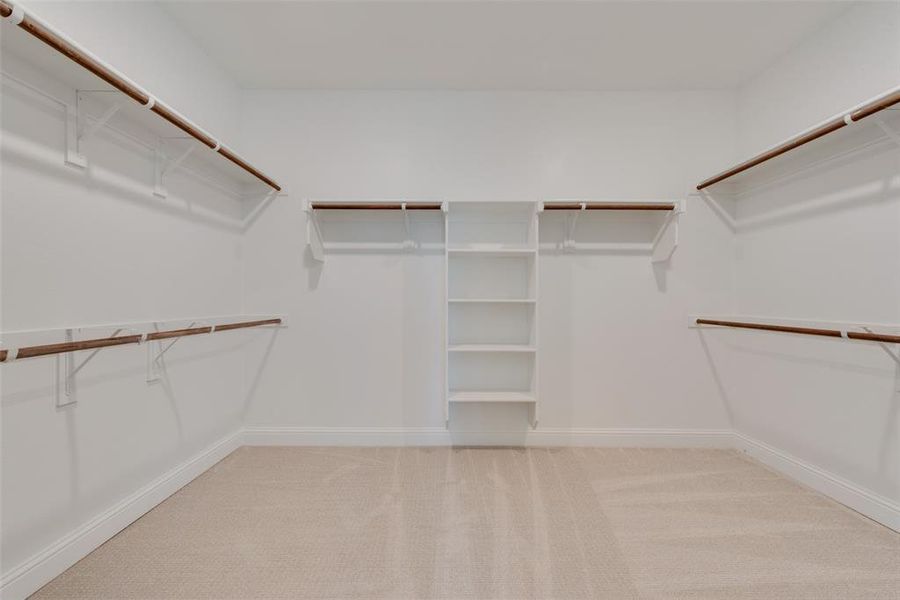 Walk in closet featuring light colored carpet