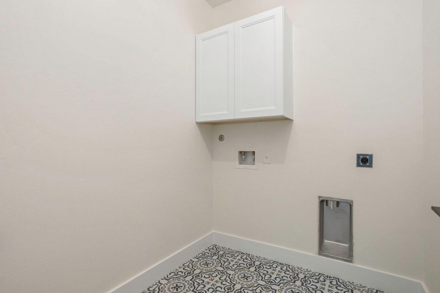 Utility room featuring patterned floor tile, white shaker cabinetry, and appliance hookups Utility room featuring patterned floor tile, white shaker cabinetry, and appliance hookups