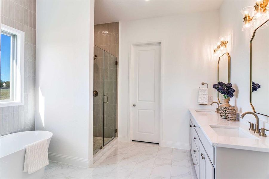 Bathroom featuring a soaking tub, double vanity, a stall shower, and light marble finish flooring Bathroom featuring a soaking tub, double vanity, a stall shower, and light marble finish flooring