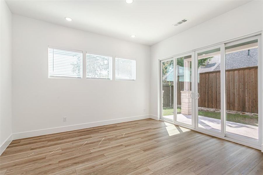 Empty room with light wood-style flooring and recessed lighting