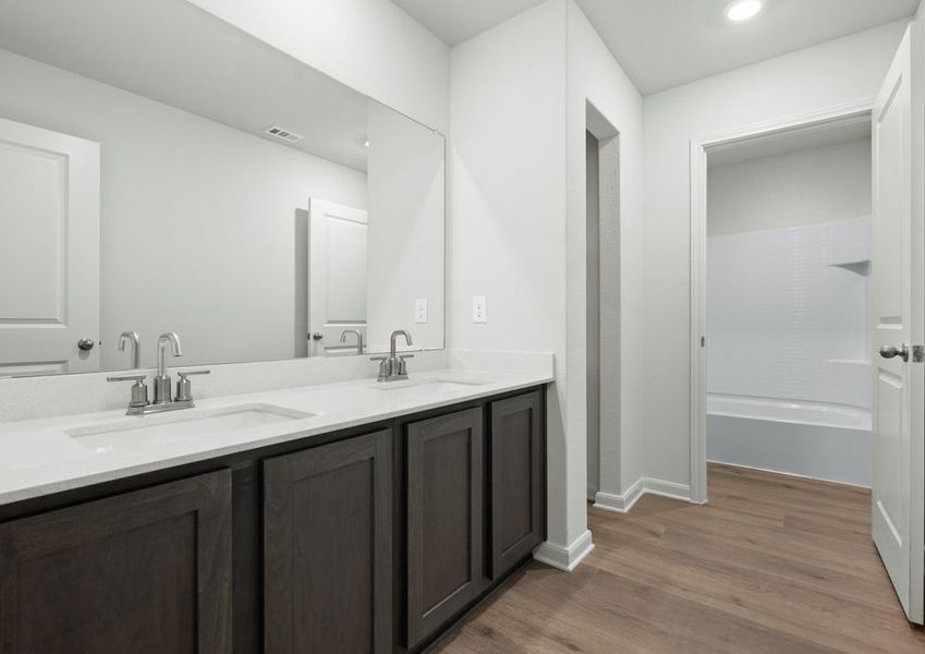 The secondary bathroom has a large vanity space and a shower-tub combo. The secondary bathroom has a large vanity space and a shower-tub combo.