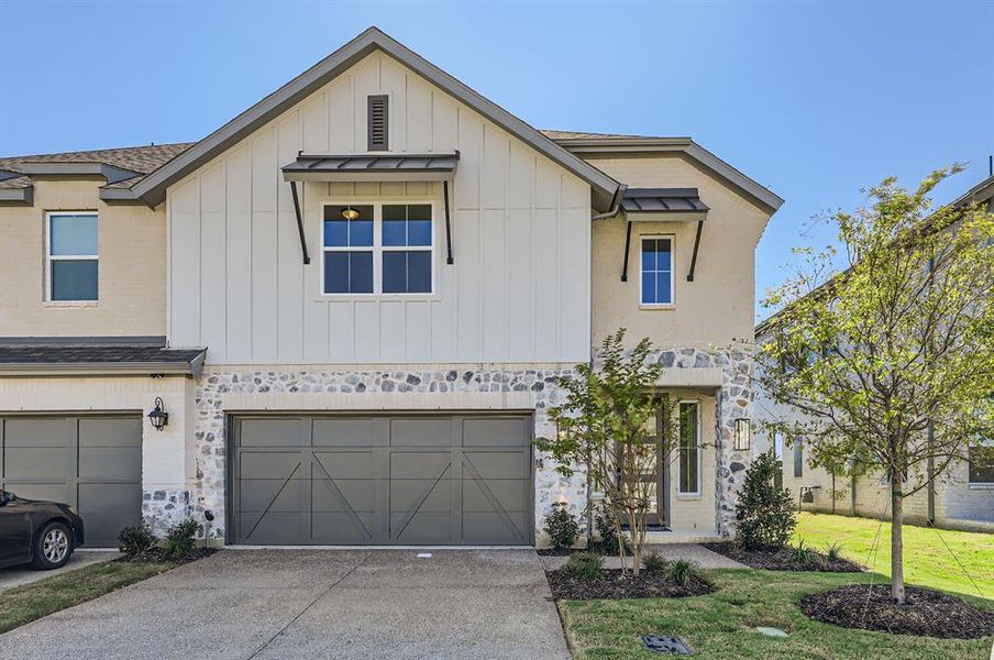 View of front of property with a front yard and a garage