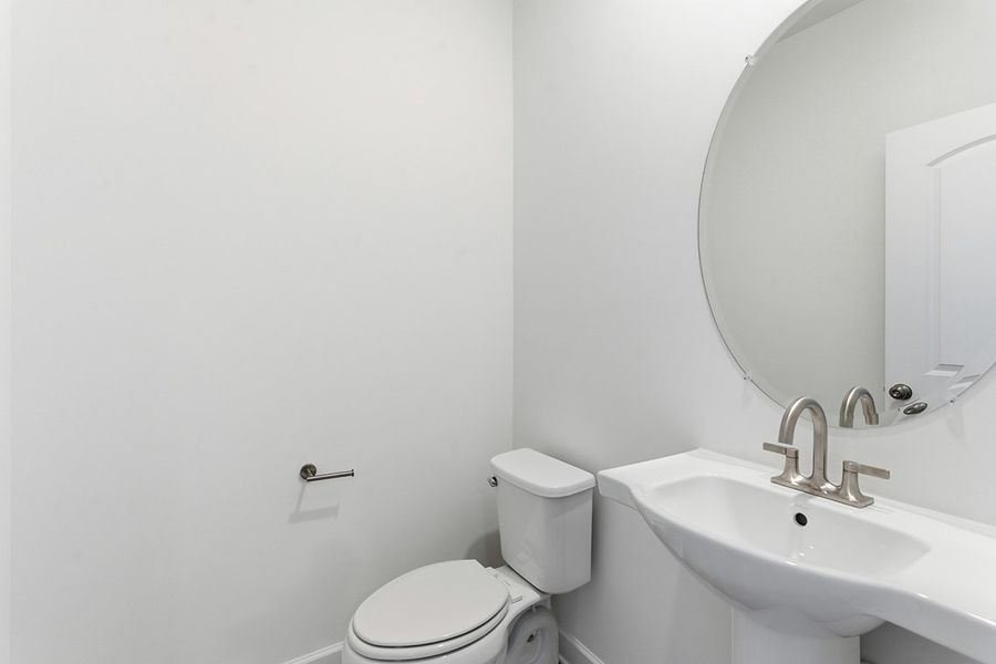 A bathroom with a round mirror.