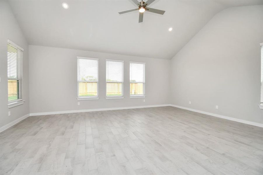 Welcome family and guests to your charming living room! With its high ceilings, recessed lighting, ceiling fan, custom paint, beautiful flooring, and large windows that let in abundant natural light, this room is perfect for gatherings. Example photo of completed home with similar plan. Actual may vary.