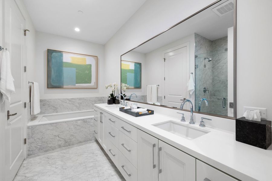 Luxurious primary bath has double sinks and elegant marble finishes.