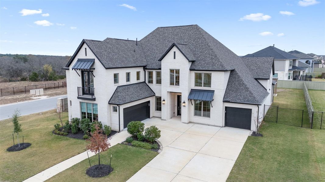 View of front of home with stucco siding, roof with shingles, a garage, and driveway
