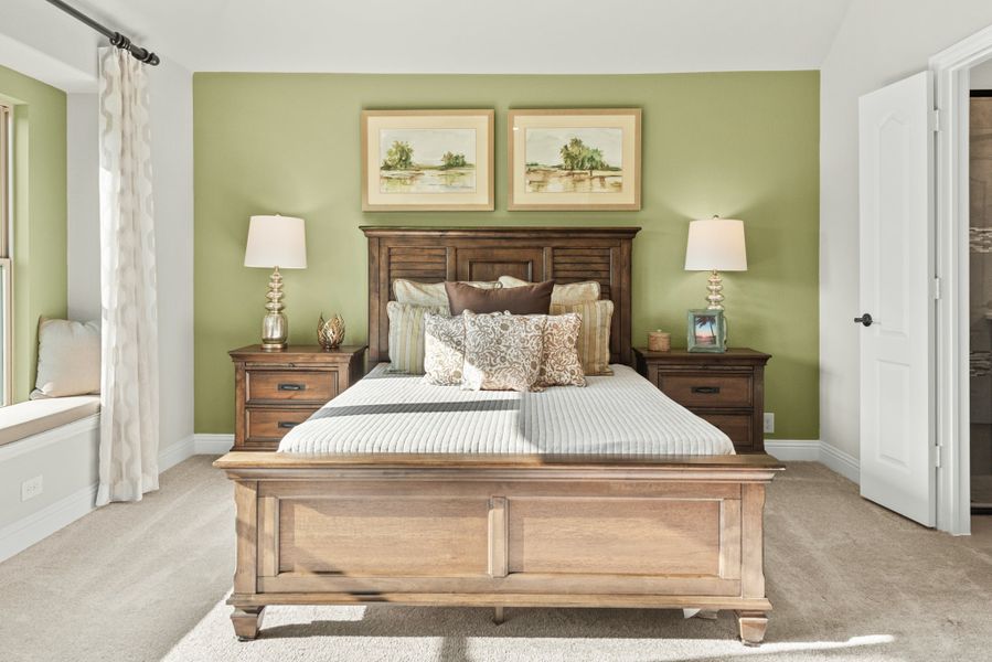 Bedroom with wood panel bed frame, green accent wall, two nightstands, and a window seat with curtains
