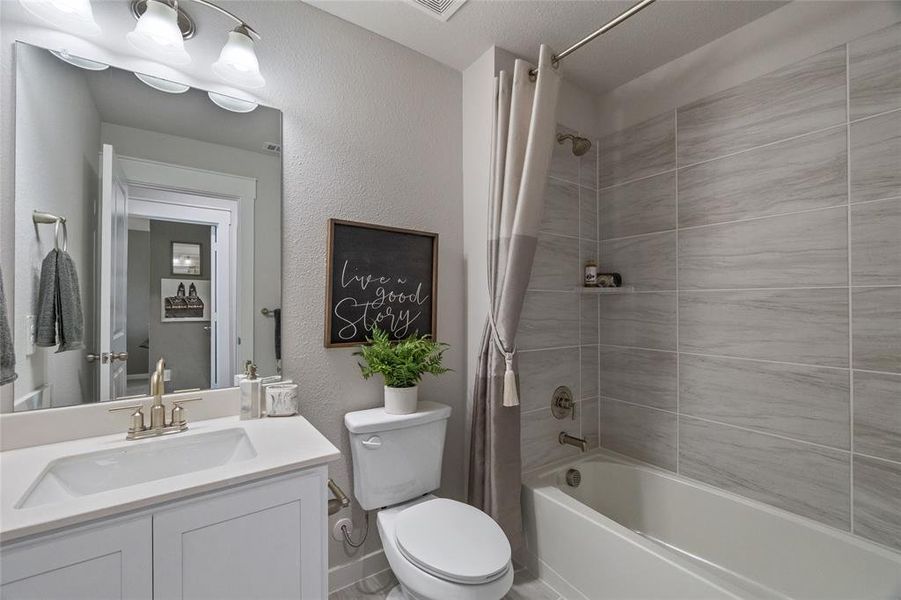 Full bathroom with shower / bath combo with shower curtain, toilet, and vanity