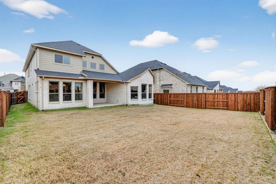 Rear view of property featuring a fenced backyard, a patio area, brick siding, and a shingled roof Rear view of property featuring a fenced backyard, a patio area, brick siding, and a shingled roof