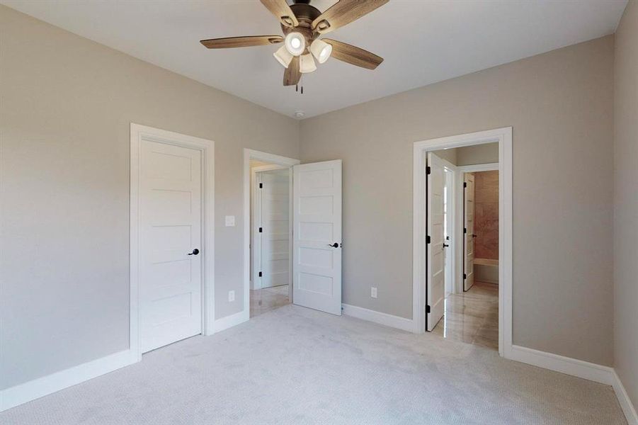 Unfurnished bedroom featuring ceiling fan and light colored carpet