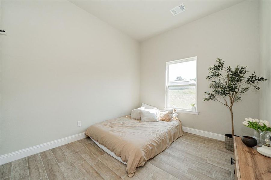 Bedroom with wood finished floors and lofted ceiling Bedroom with wood finished floors and lofted ceiling