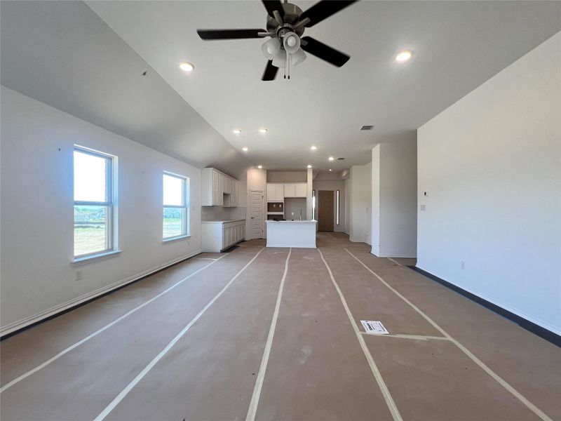 Unfurnished living room with recessed lighting, ceiling fan, and lofted ceiling