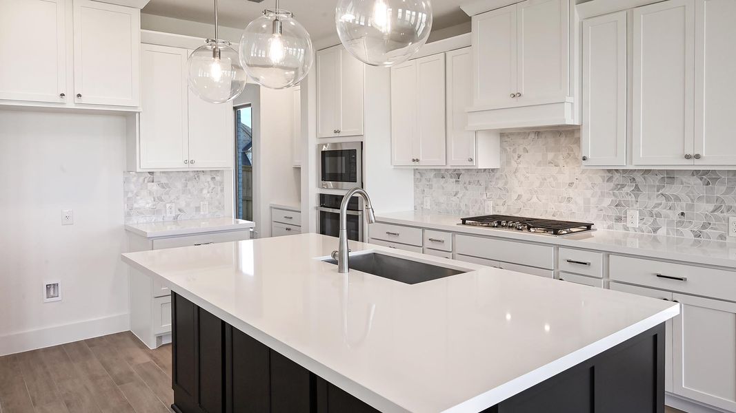 Kitchen with light countertops, white cabinets, and decorative backsplash