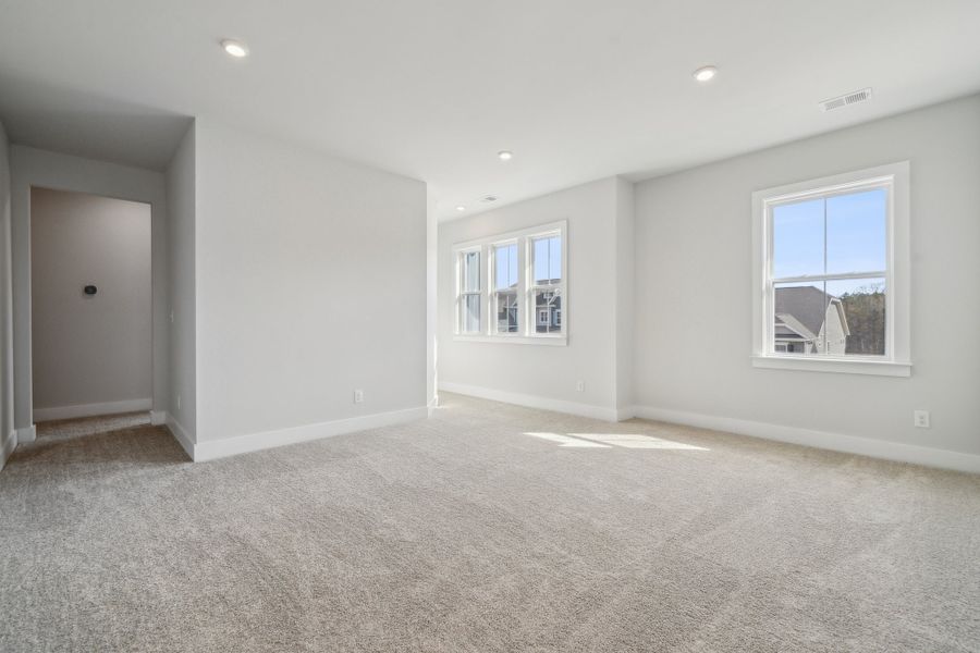 A room with a carpet and windows.