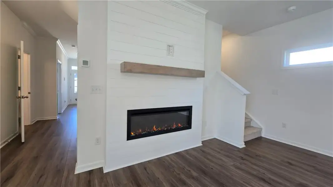 A modern fireplace with a rustic mantel anchors th