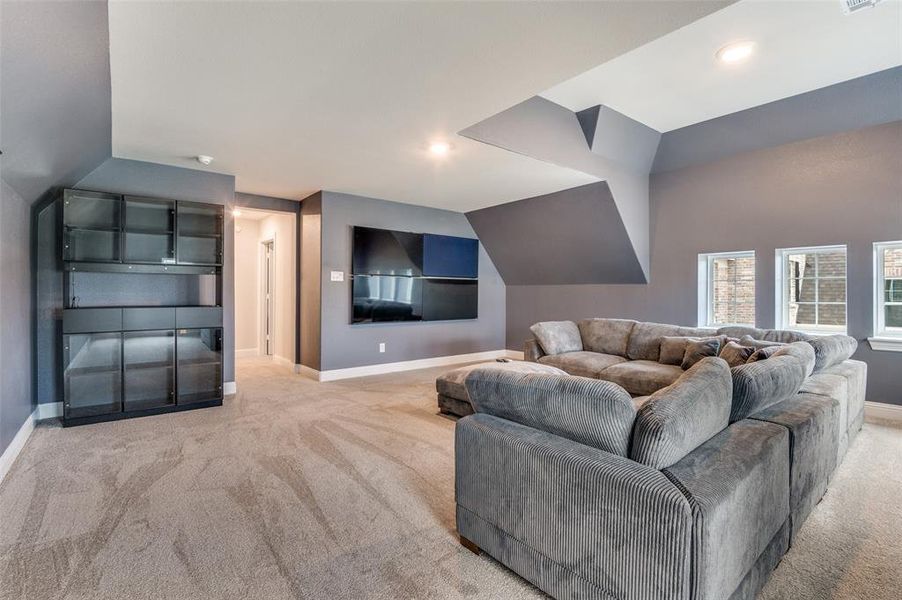 Living room featuring light colored carpet and lofted ceiling