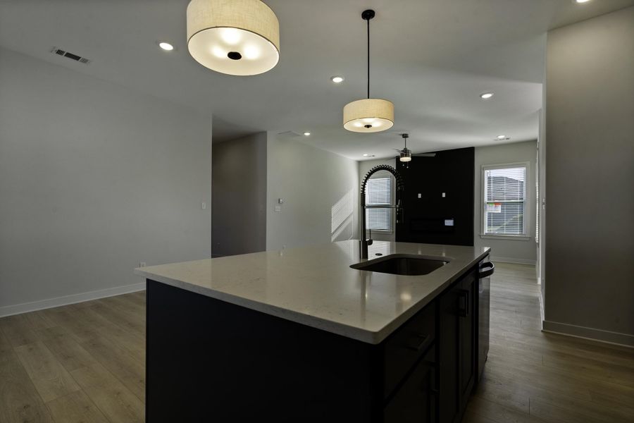 Kitchen island with a light-toned countertop and an undermount sink