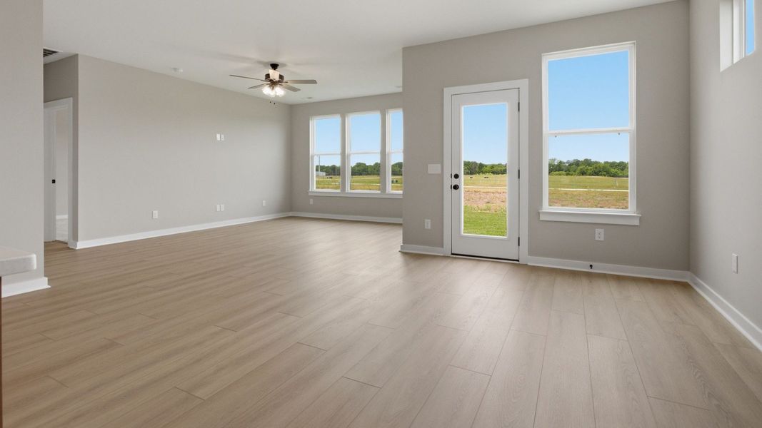 Gathering and dining area with access to back entry and bright natural light through windows Gathering and dining area with access to back entry and bright natural light through windows