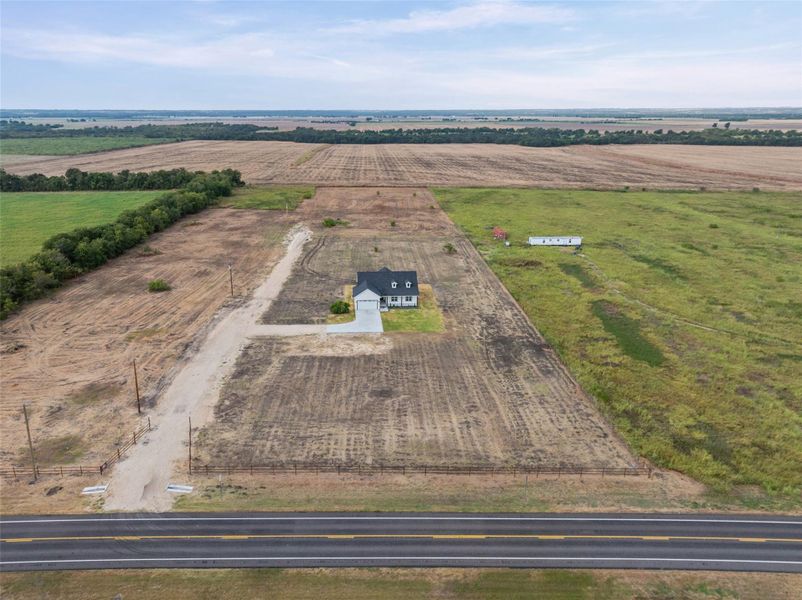 An expansive rural landscape surrounds this newly constructed home sitting on a generous acreage lot.