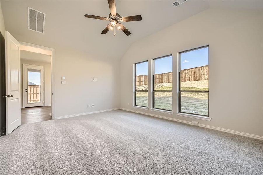 Carpeted spare room featuring ceiling fan and lofted ceiling